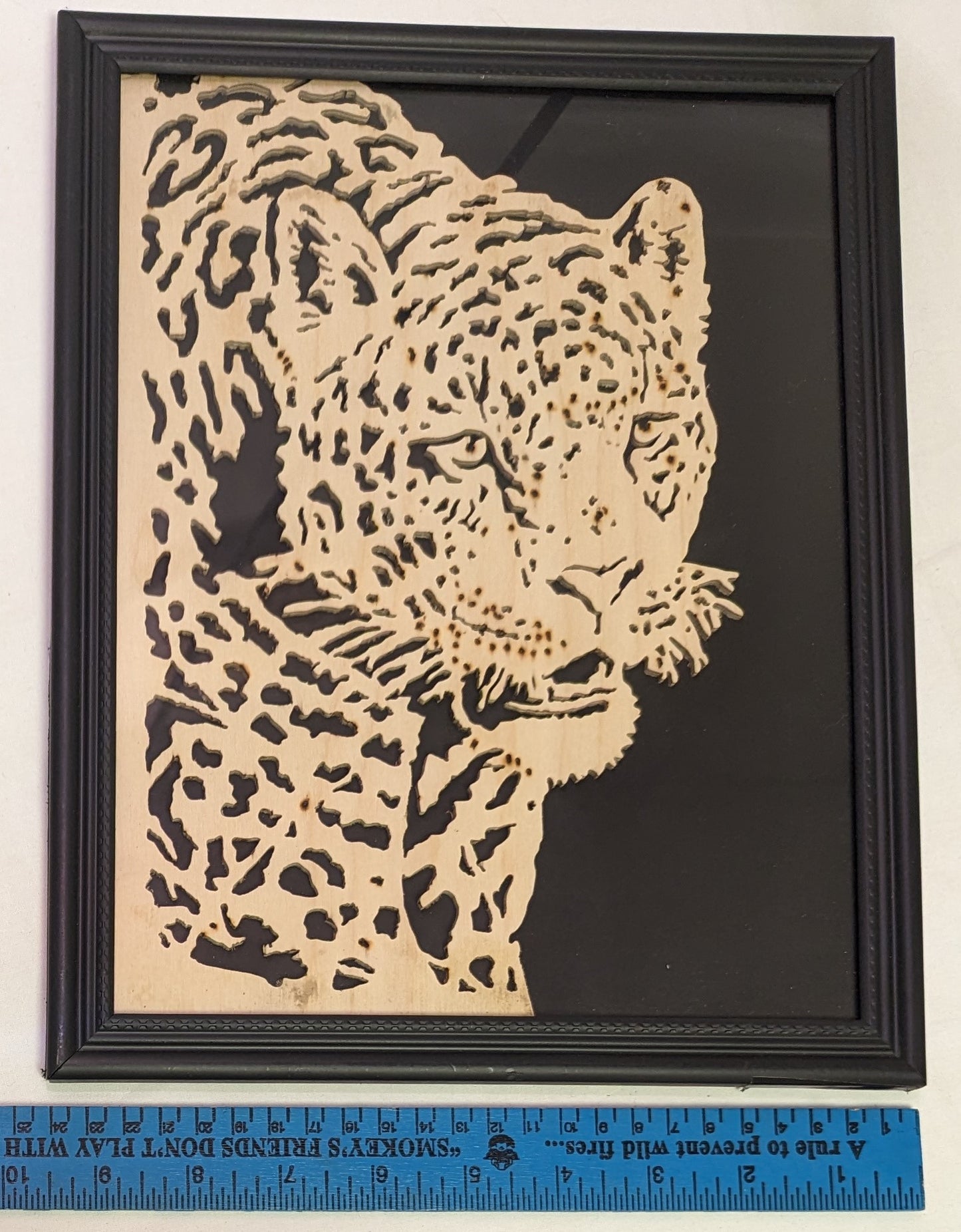 Art Scroll saw cut out negative . Snarling Leopard in frame under glass