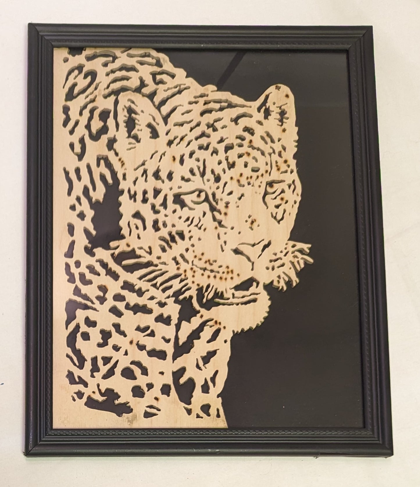 Art Scroll saw cut out negative . Snarling Leopard in frame under glass
